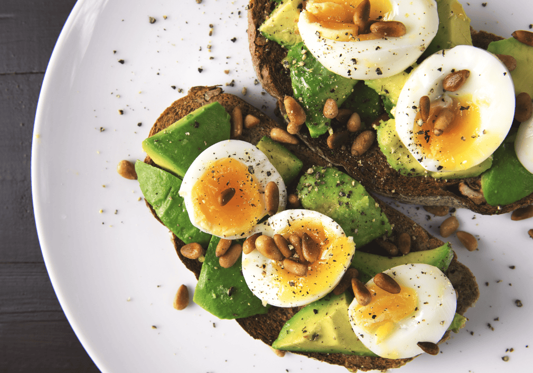 Zuurdesembrood met avocado, zachtgekookt ei en pijnboompitten